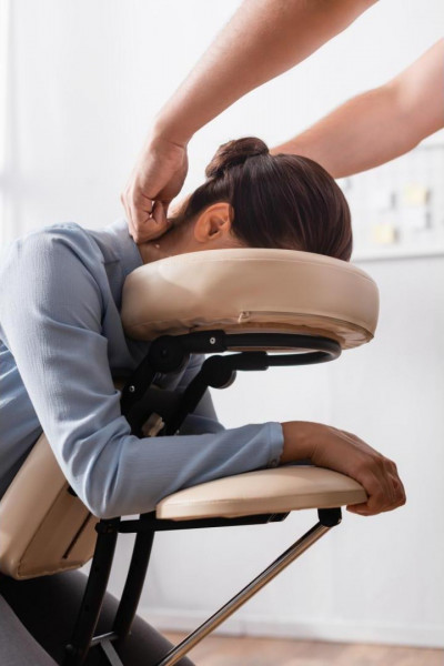 femme se faisant masser le cou sur une chaise