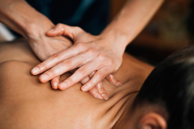 massage du dos pression sur la colonne vertébrale avec les deux mains