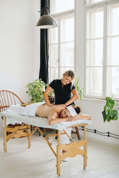femme massant le dos d'une cliente sur une table de massage