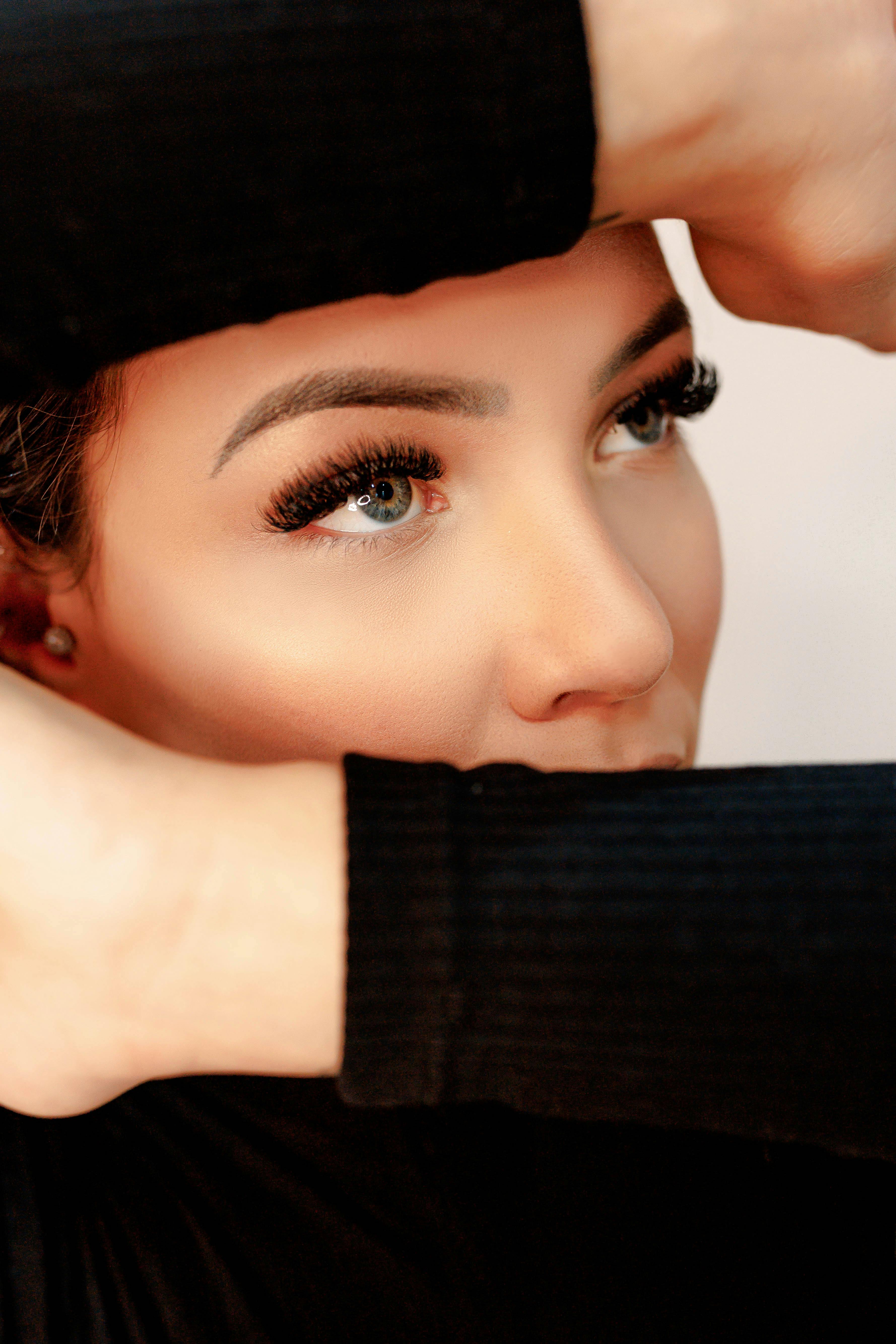 Femme qui cache son visage et laisse ses yeux avec une extension de cils en volume russe